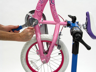 Rotate the bike in the stand to make components easier to reach. This nut tightens counter-clockwise.