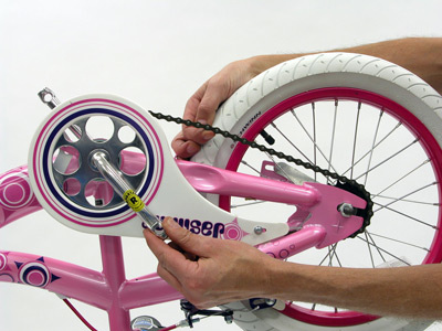 Pink bicycle upside-down checking chain tension