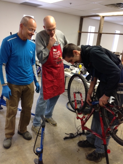 Calvin Jones working with volunteer mechanics Tim Parker and John Sutcliffe