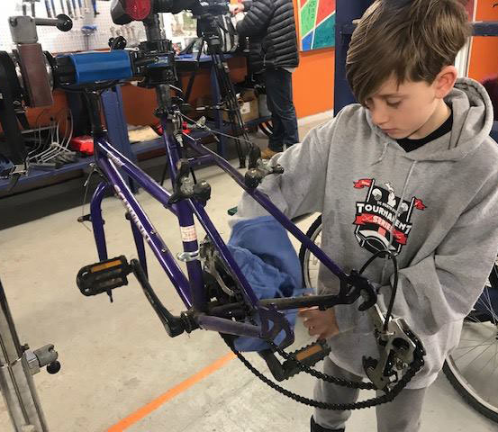 Norte youth cycling Park Tool grant winner working on a bike