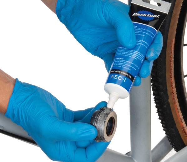 The Park Tool ASC-1 Anti-Seize Compound being applied to threads of bottom bracket cup, click to enlarge
