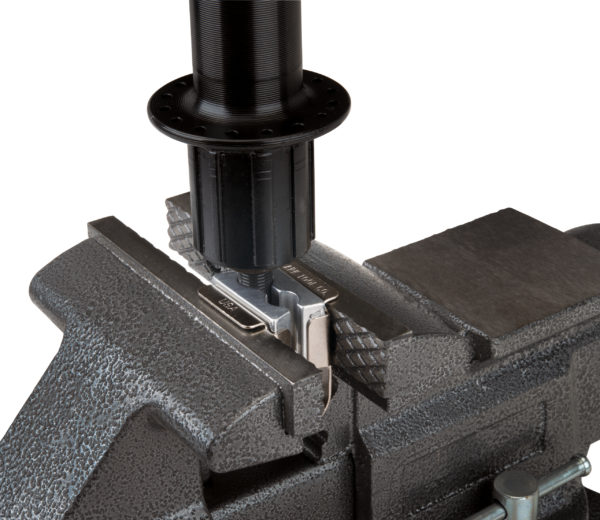 The Park Tool AV-1 Axle Vise holding a bicycle hub axle in a bench vise, click to enlarge