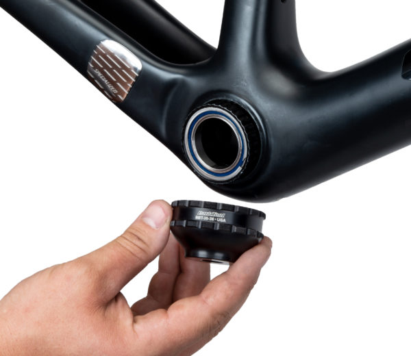 A hand fitting the BBT-35-36 Bottom Bracket Tool onto a black external bottom bracket cup on a bike frame, click to enlarge