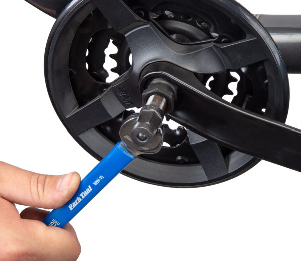 The Park Tool CWP-7 Compact Crank Puller extracting a crank arm from a gray bicycle frame., click to enlarge