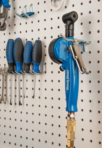 The Park Tool INF-2 Shop Inflator hanging from a hook on a white pegboard, click to enlarge