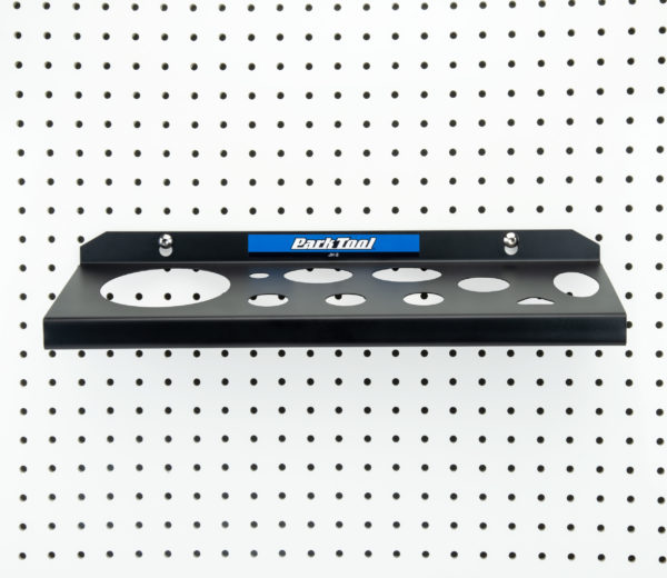 The Park Tool JH-2 Wall-Mounted Lubricant & Compound Organizer mounted to white pegboard, click to enlarge
