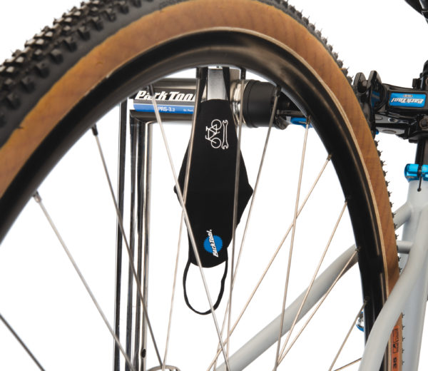 Park Tool MSK-1 Face Mask hanging from a PRS-3.2-2 with bicycle wheel in front, click to enlarge
