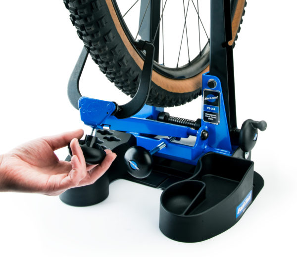 Hand turning knob to adjust calipers on a TS-2.3 Professional Wheel Truing Stand holding a MTB wheel, click to enlarge