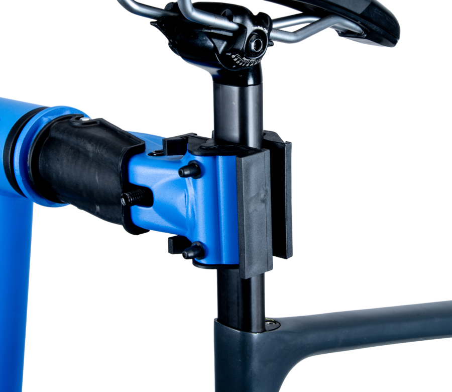 The Park Tool 1971 Clamp Adapter for D-Shaped Seatposts mounted in a PCS-10.3 repair stand clamp, holding a D-shaped seatpost on a road bike., enlarged