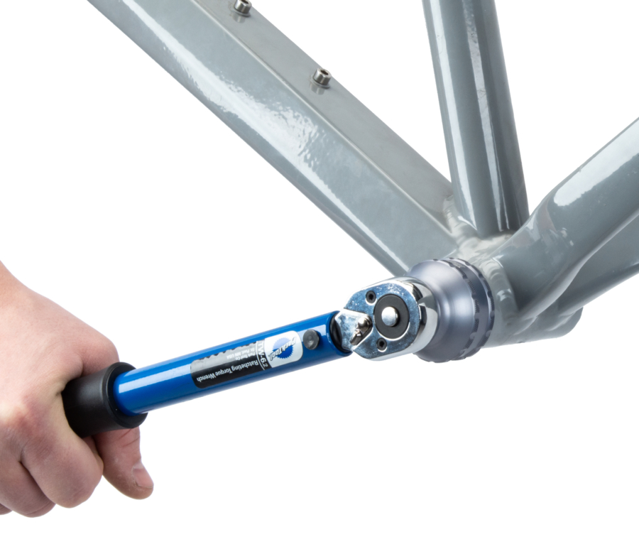 The BBT-59.3 Bottom Bracket Tool tightening an external cup on a gray MTB frame using TW-6.2 torque wrench, enlarged