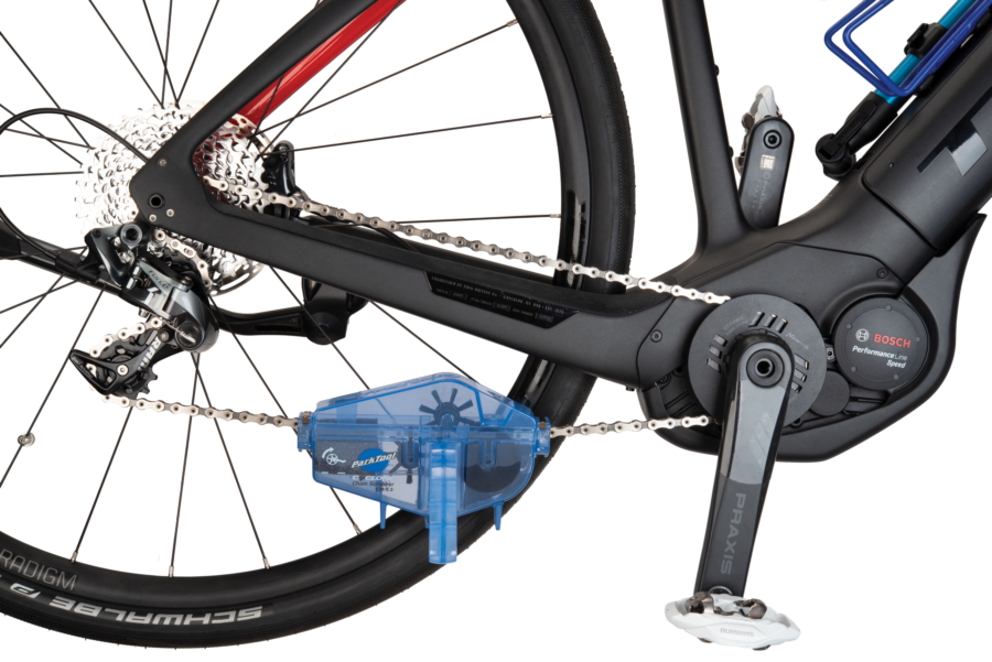 Park Tool CM-5.3 Cyclone™ Chain Scrubber installed on one way electrical bicycle chain, enlarged