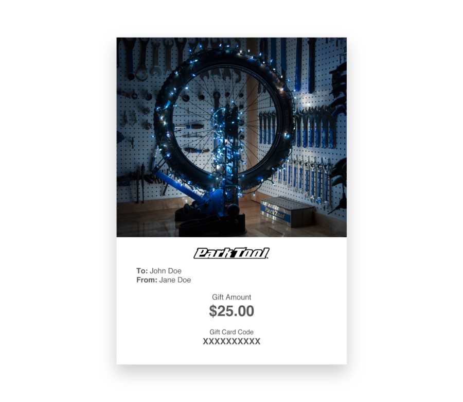 Gift card purchase under a bicycle wheel lit up with Christmas lights, enlarged