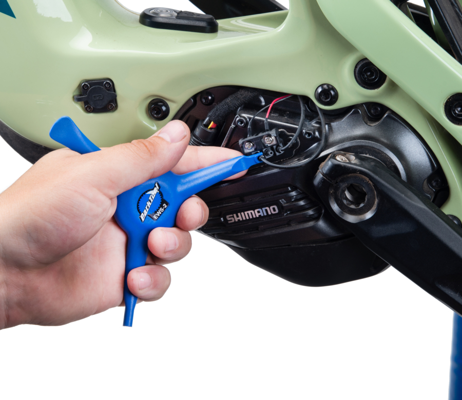 The Park Tool EWS-2 removing an E-tube® cord from a Shimano® e-bike motor, enlarged