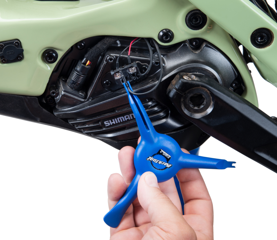 The Park Tool EWS-2 removing an E-tube® cord from a Shimano® e-bike motor, enlarged