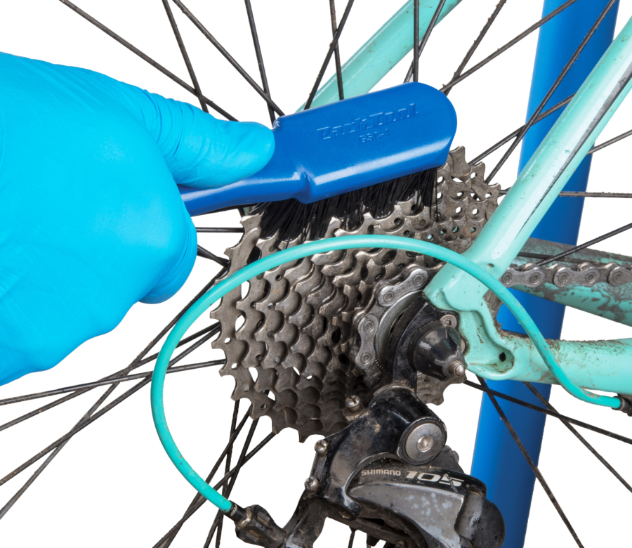 The Park Tool GSC-4 Bicycle Cassette Cleaning Brush cleaning cassette cogs, enlarged