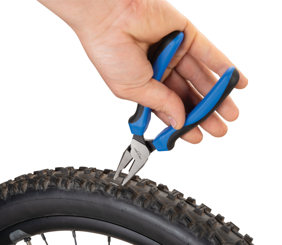 Park Tool LP-7 Utility Pliers removing staple from bicycle tire, enlarged