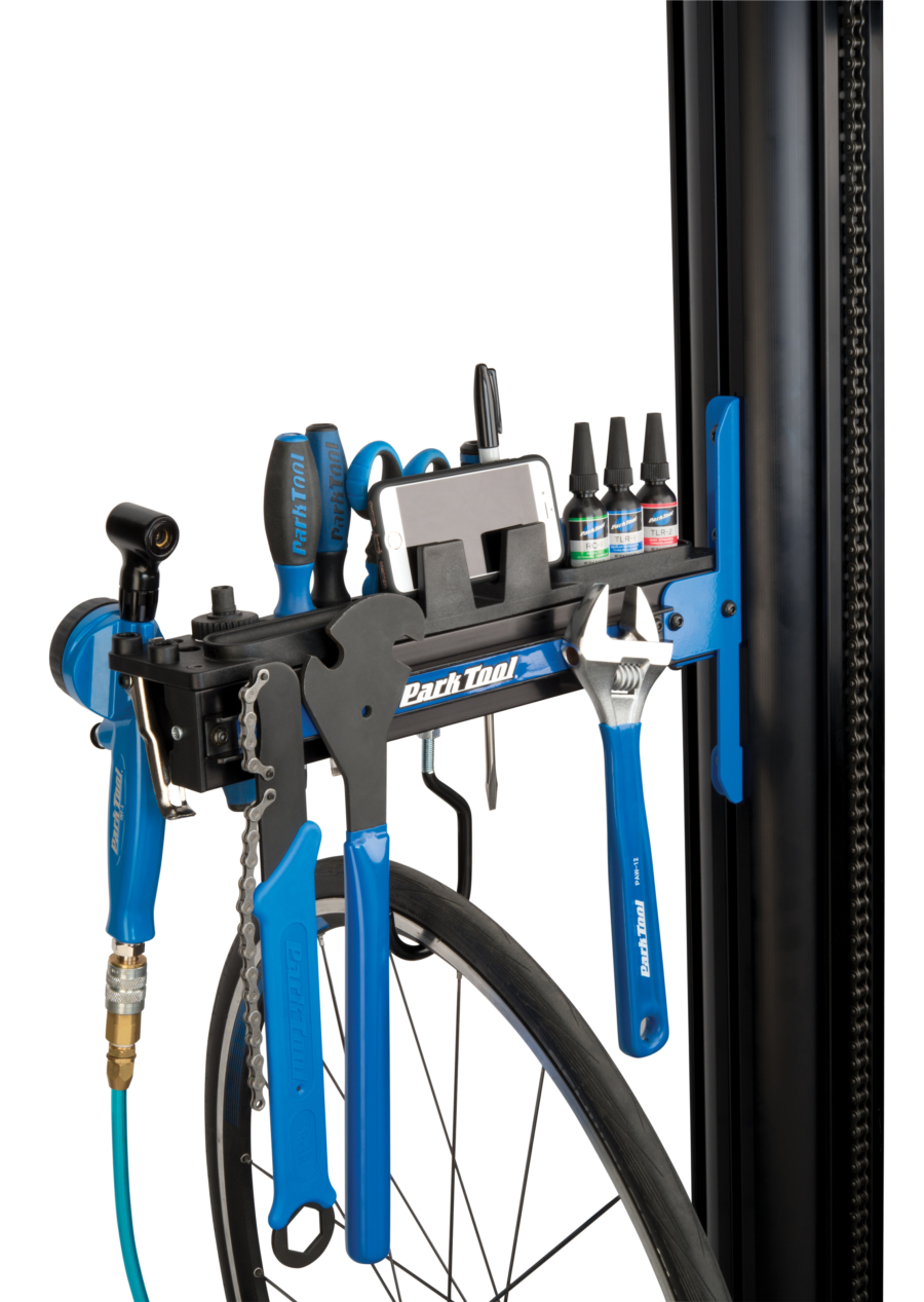 The Park Tool PRS-33TT Deluxe Tool and Work Tray full of tools and a phone attached to repair stand, enlarged
