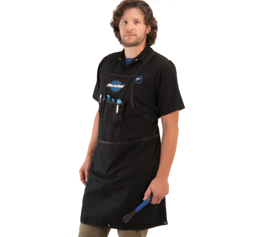 Model wearing the Park Tool SA-3 Heavy Duty Shop Apron with tools in pocket and bottom of apron down, enlarged