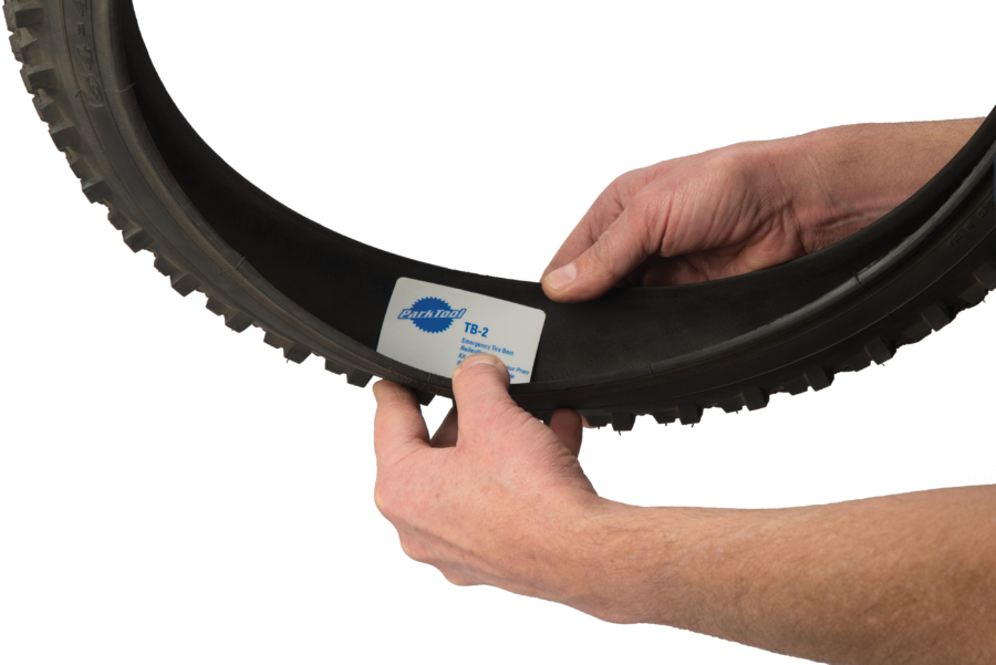 The Park Tool TB-2 Emergency Tire Boots being applied to inside of bike tire, enlarged