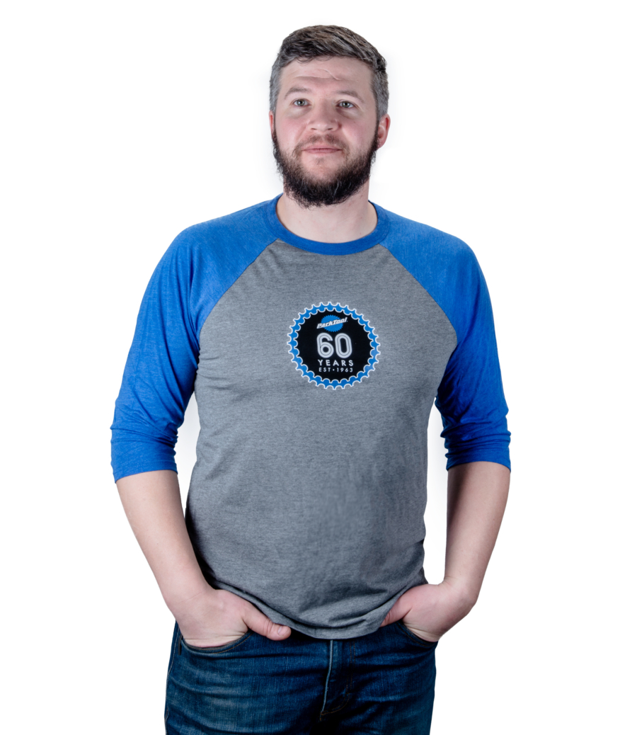 The Park Tool TSH-60 60th Anniversary Baseball Tee — Unisex, being worn by Park Tool tech guy Truman., enlarged