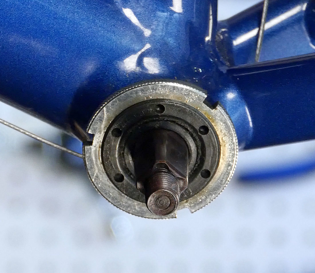 Closeup of cup-and-cone style bottom bracket installed in steel bicycle frame bottom bracket shell