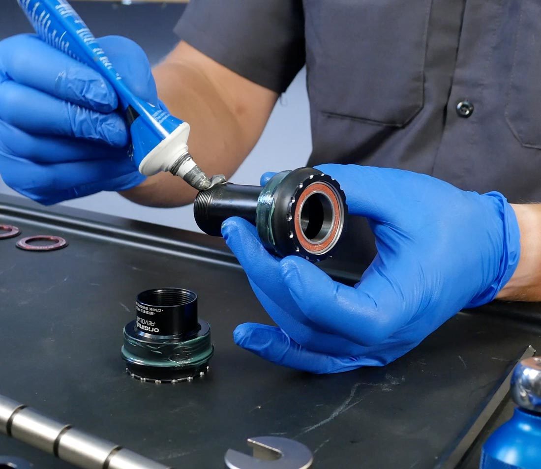 Half of thread-together bottom bracket system held to apply ASC-1 anti-seize to threads