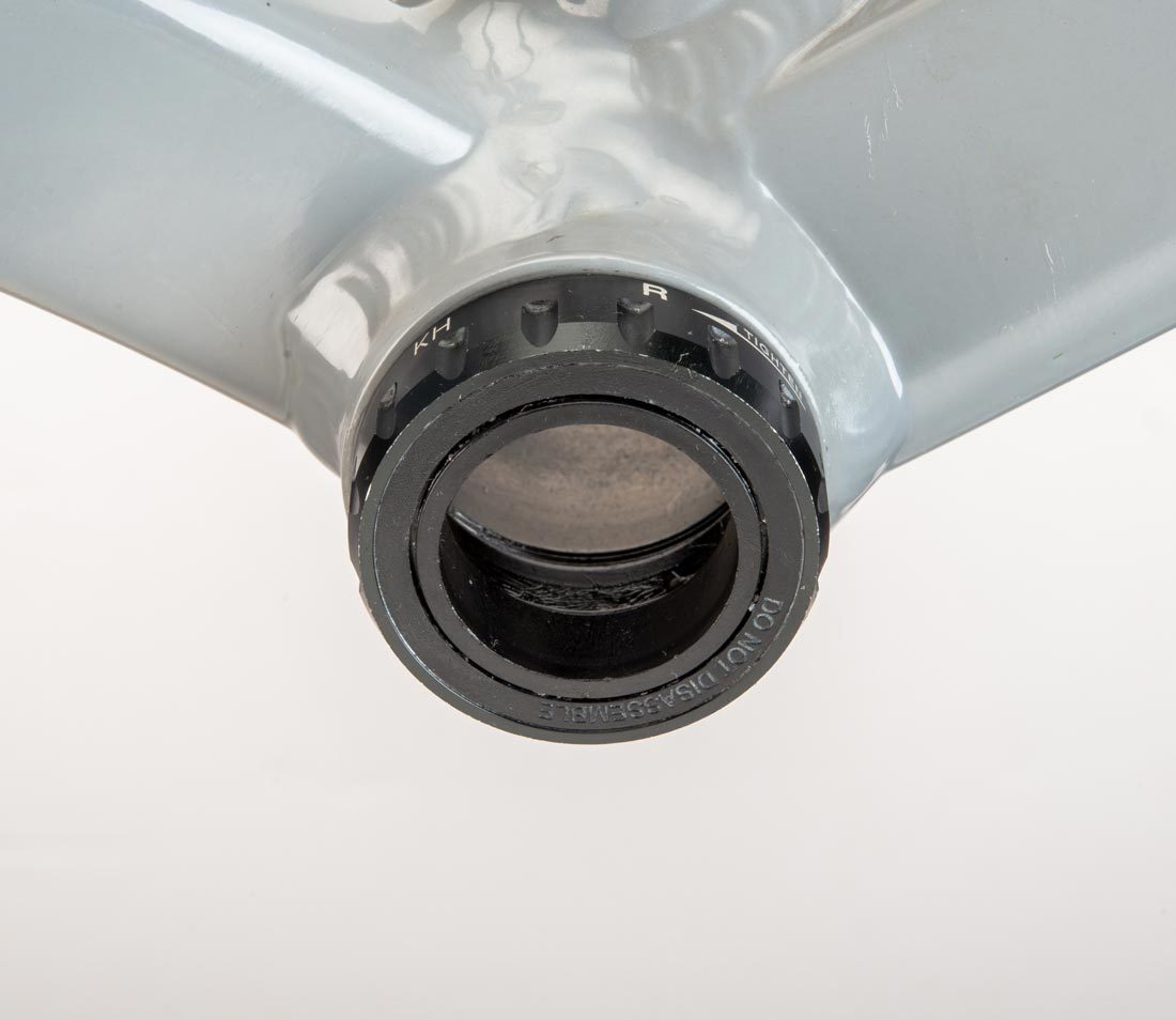 Threaded bottom bracket cup with 16 external notches, installed in bottom bracket shell on gray alloy frame