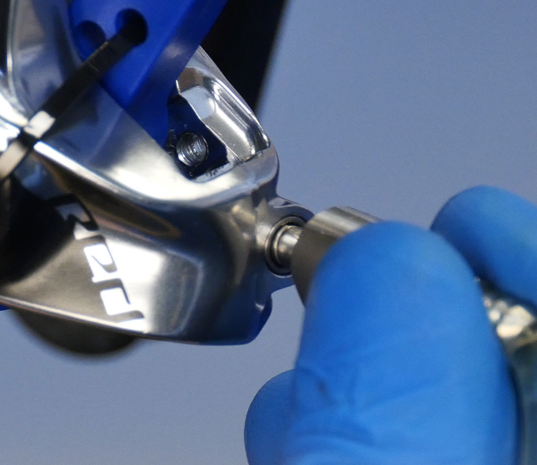 Closeup of syringe hose end with Bleeding Edge adaptor being inserted and snapped into port on brake caliper