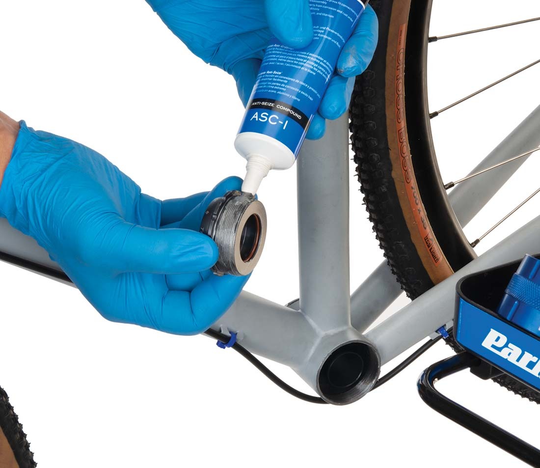 Anti-seize compound being applied to the threads of a bottom bracket cup