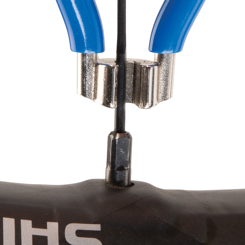 Blue SW-3 spoke wrench being fitted to square spoke nipple on wheel