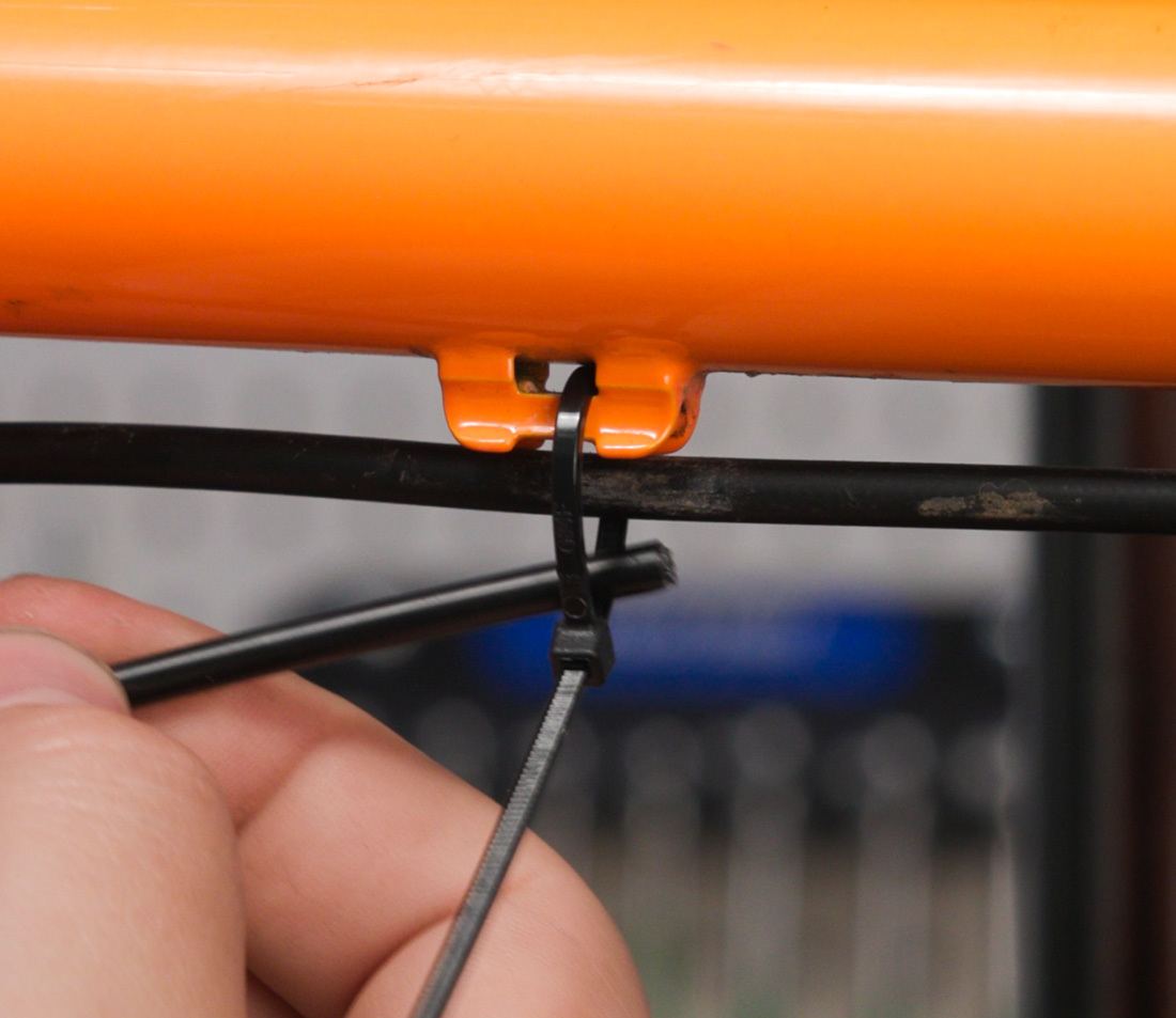 Feed the housing through the loop of each partially-tightened zip tie
