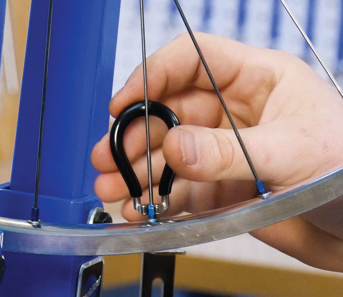 Spoke wrench making an adjustment to a bicycle spoke nipple