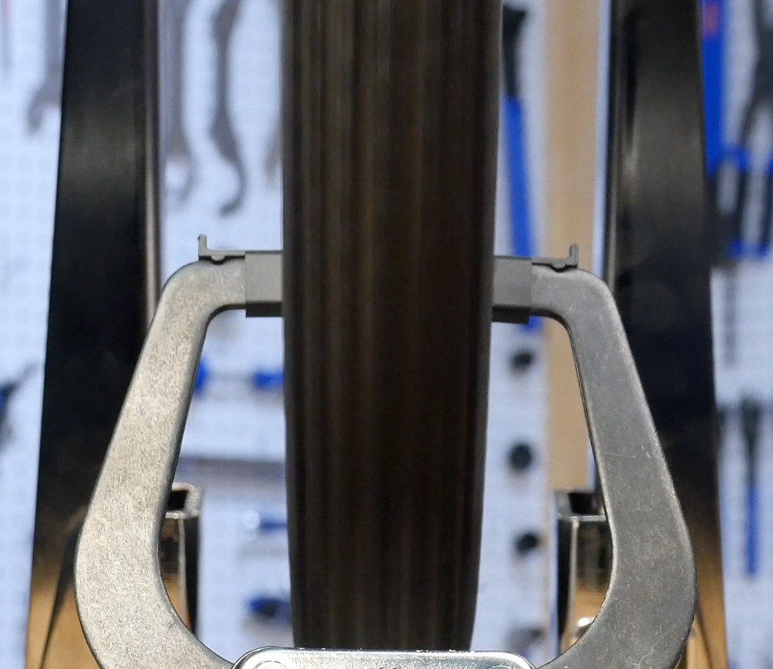 Head-on view of bicycle wheel in truing stand, demonstrating the tire hiding the truing stand indicators